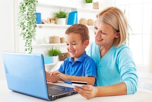 Mom helping boy on computer