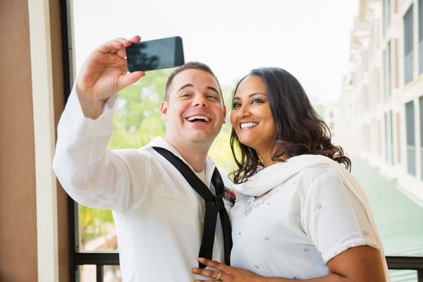 Newlywed American sailor shooting selfie with his wife