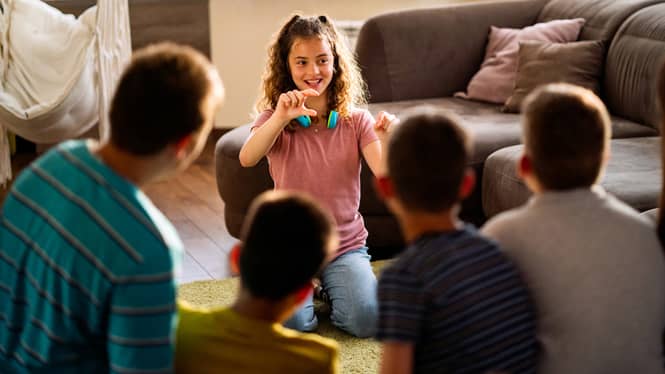 A blended family playing emotion charades as a technique to bond and regulate emotions.