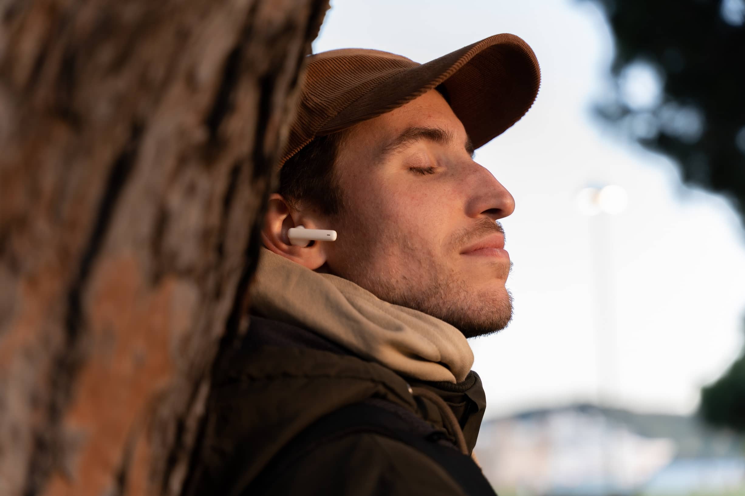 A relaxed man with his eyes closed listening to music with headphones.