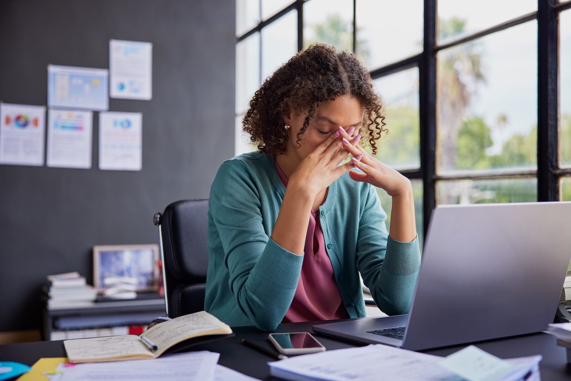 A stressed and overwhelmed multi-ethnic businesswoman at work.