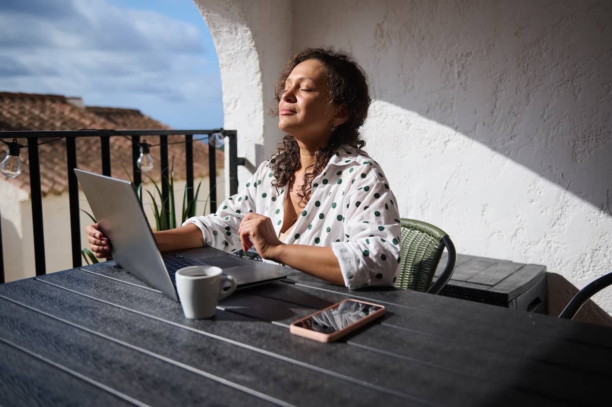 A woman enjoys sunlight on her face as a stress management strategy.