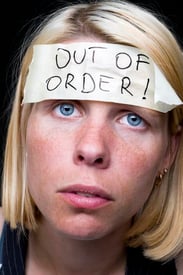 A young woman wearing an out-of-order sticker on her forehead signifying unhealthy bottled emotions.