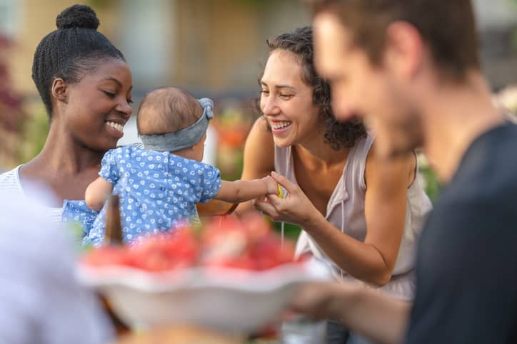 Adult friends dining on a patio: in an interconnected society, the ability to empathize is at its foundation.