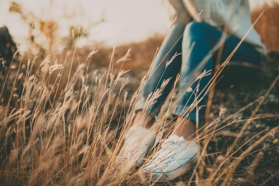 A woman stopping to rest in a meadow