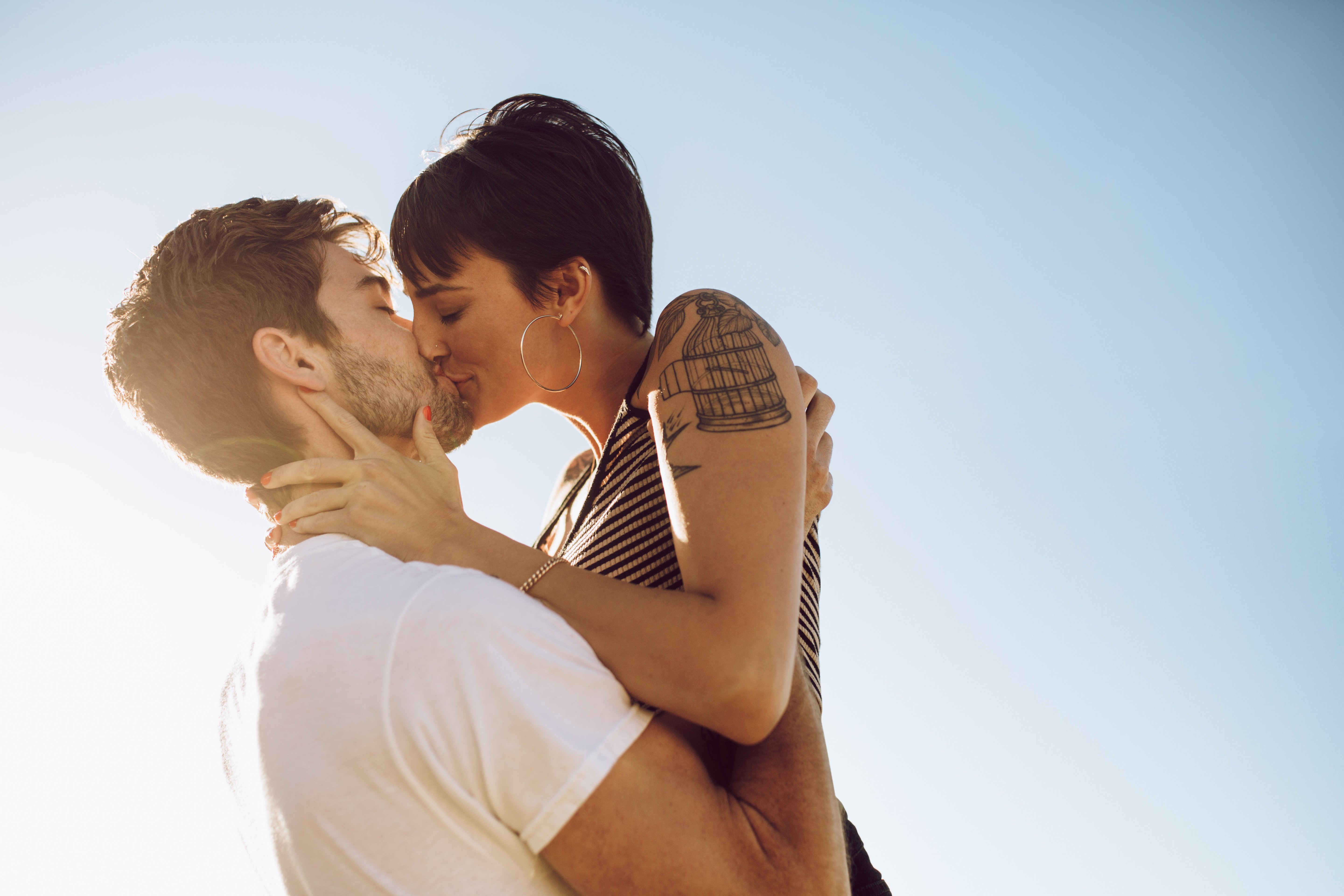 A young couple kissing with blue sky