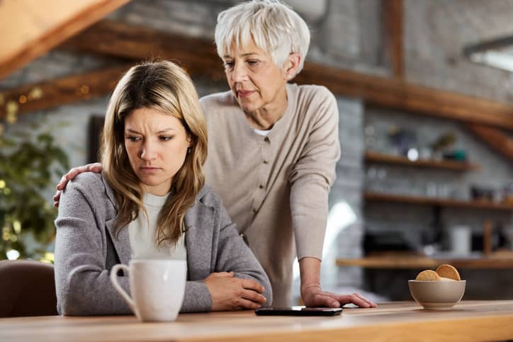 Adult child pulls away from her mother as she tells her everything will be ok