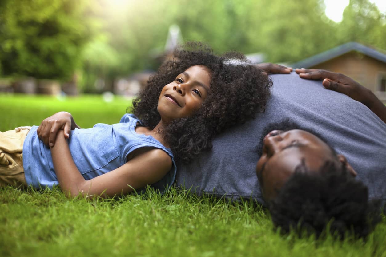 Father and daughter relaxing in the yard after school