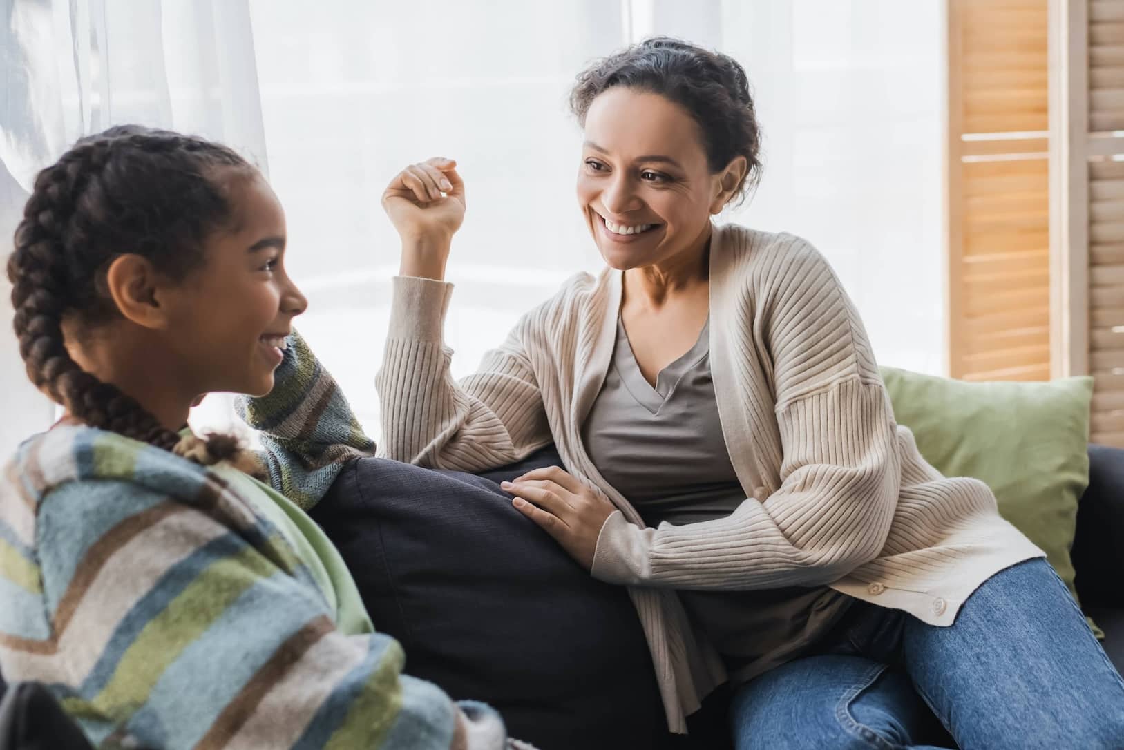 An African American mother teaching her preteen daughter thinking skills.