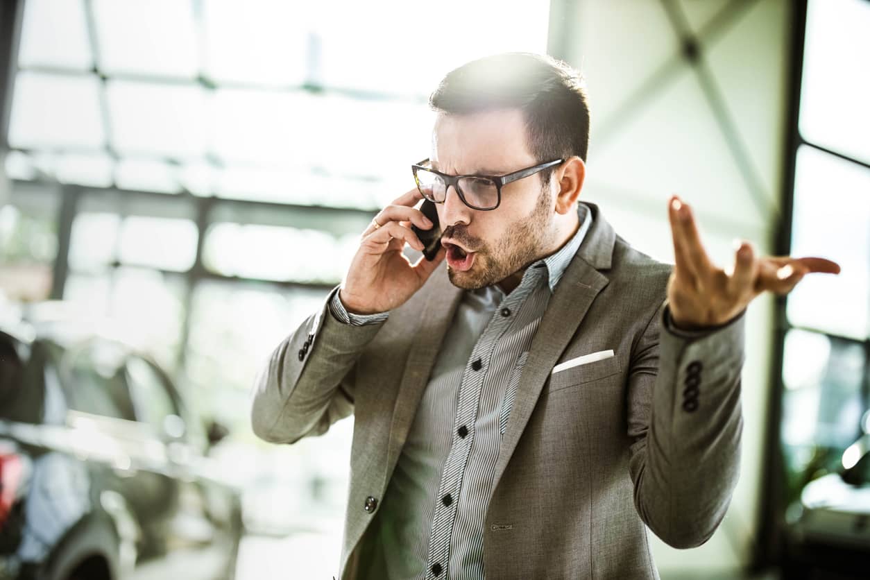 Angry businessman and COO talking on his cell phone.