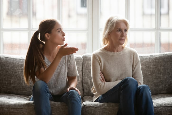 Annoyed and upset adult daughter expressing complaints to her mother.