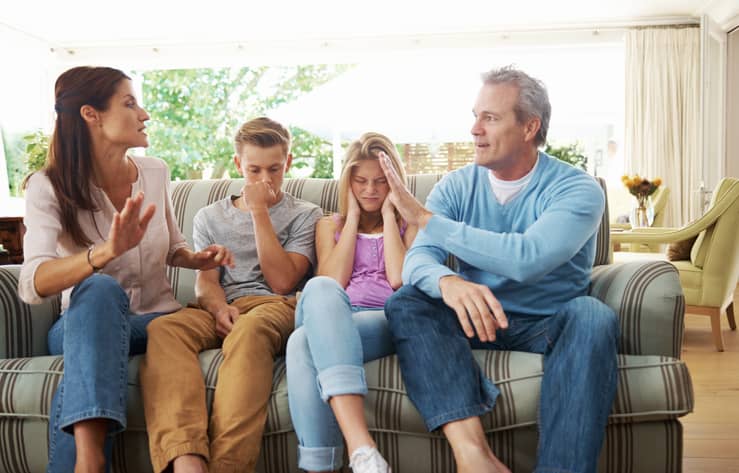 Two parents arguing with their teenage kids stuck in the middle.