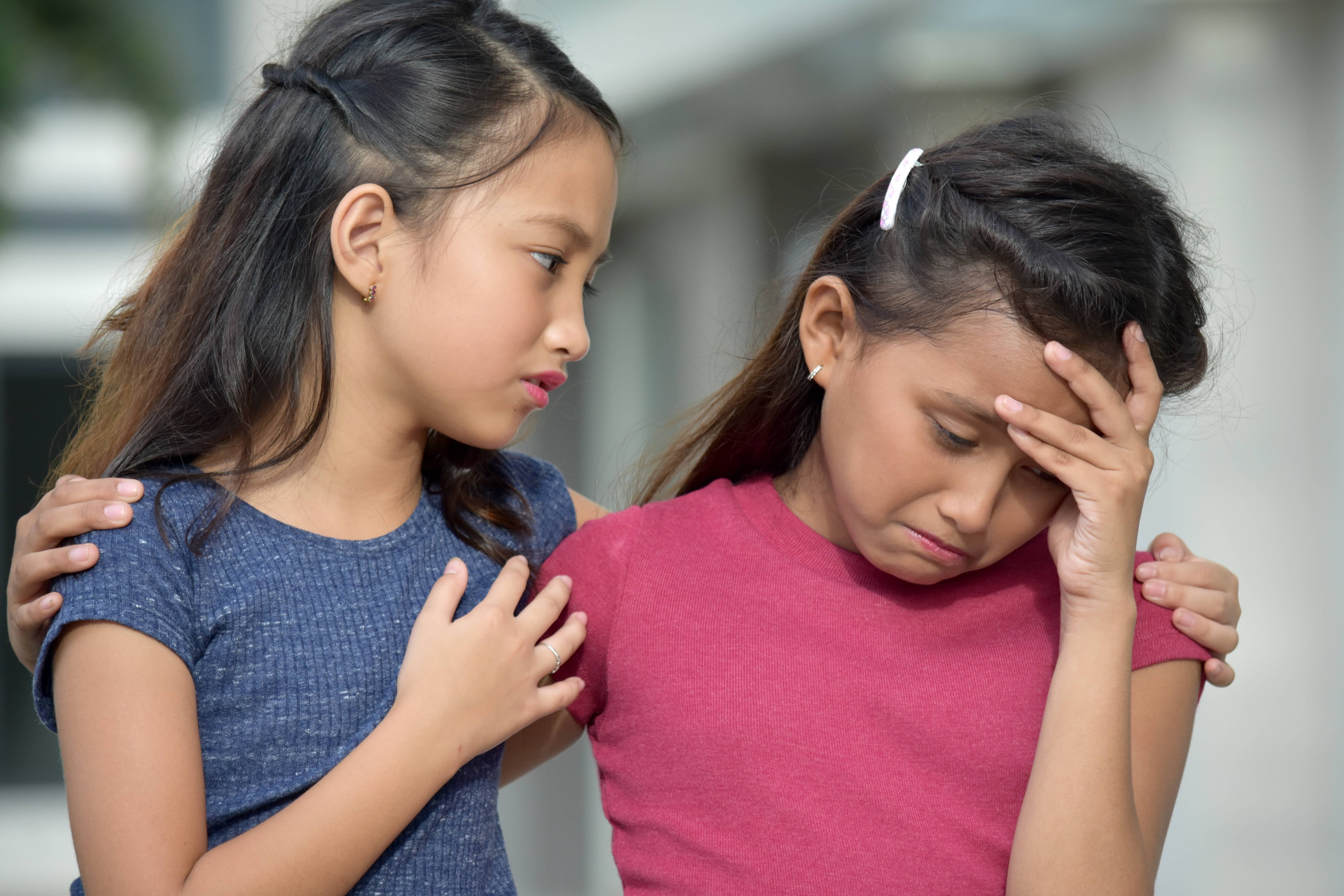 Asian girl shows compassion for a sad friend.