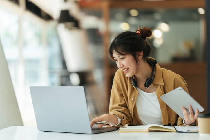 Asian woman studying a course online, exhibiting focus and delayed gratification.