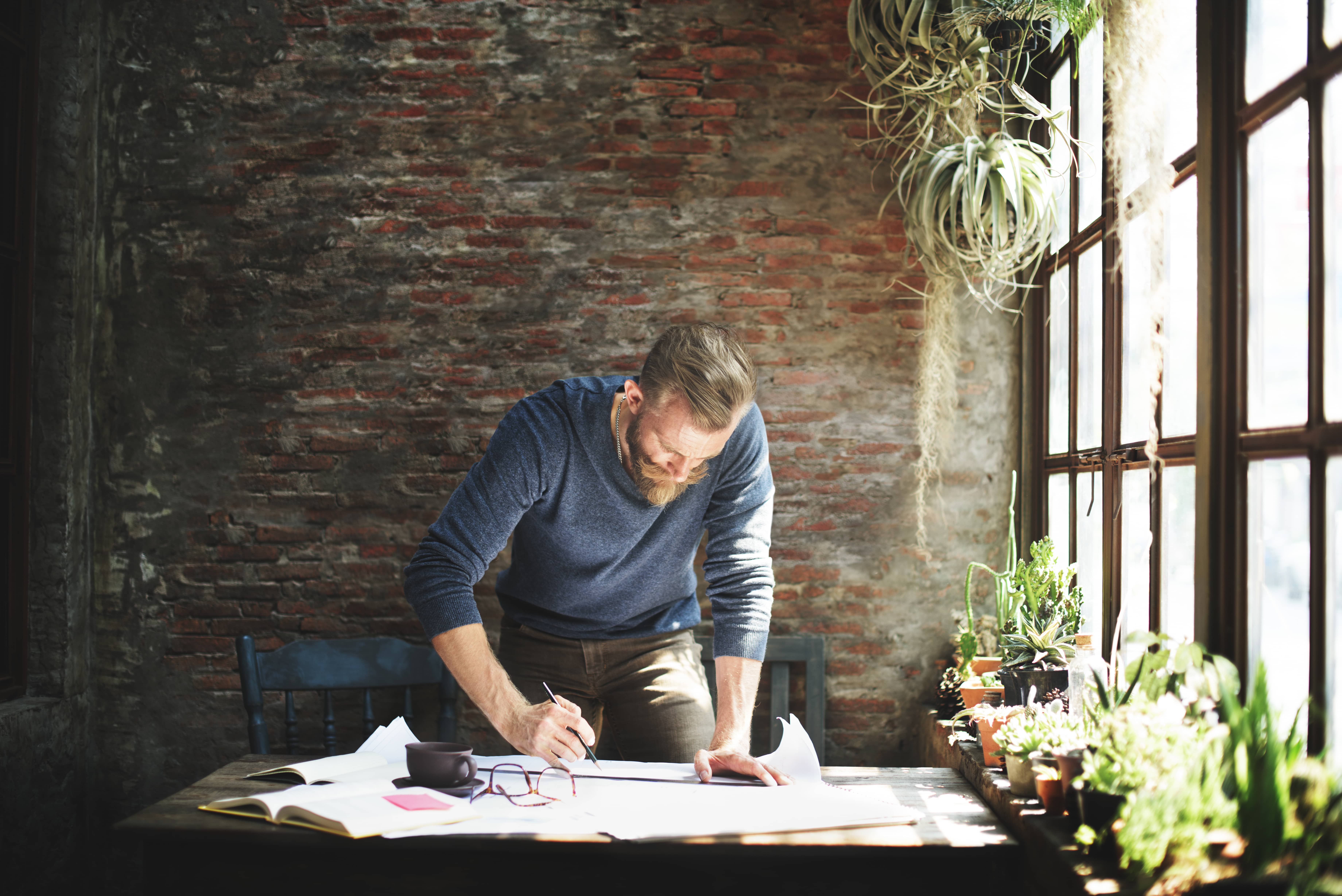 Bearded man studying market trends in his office.