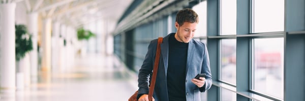 Business man walking while texting on his Iphone