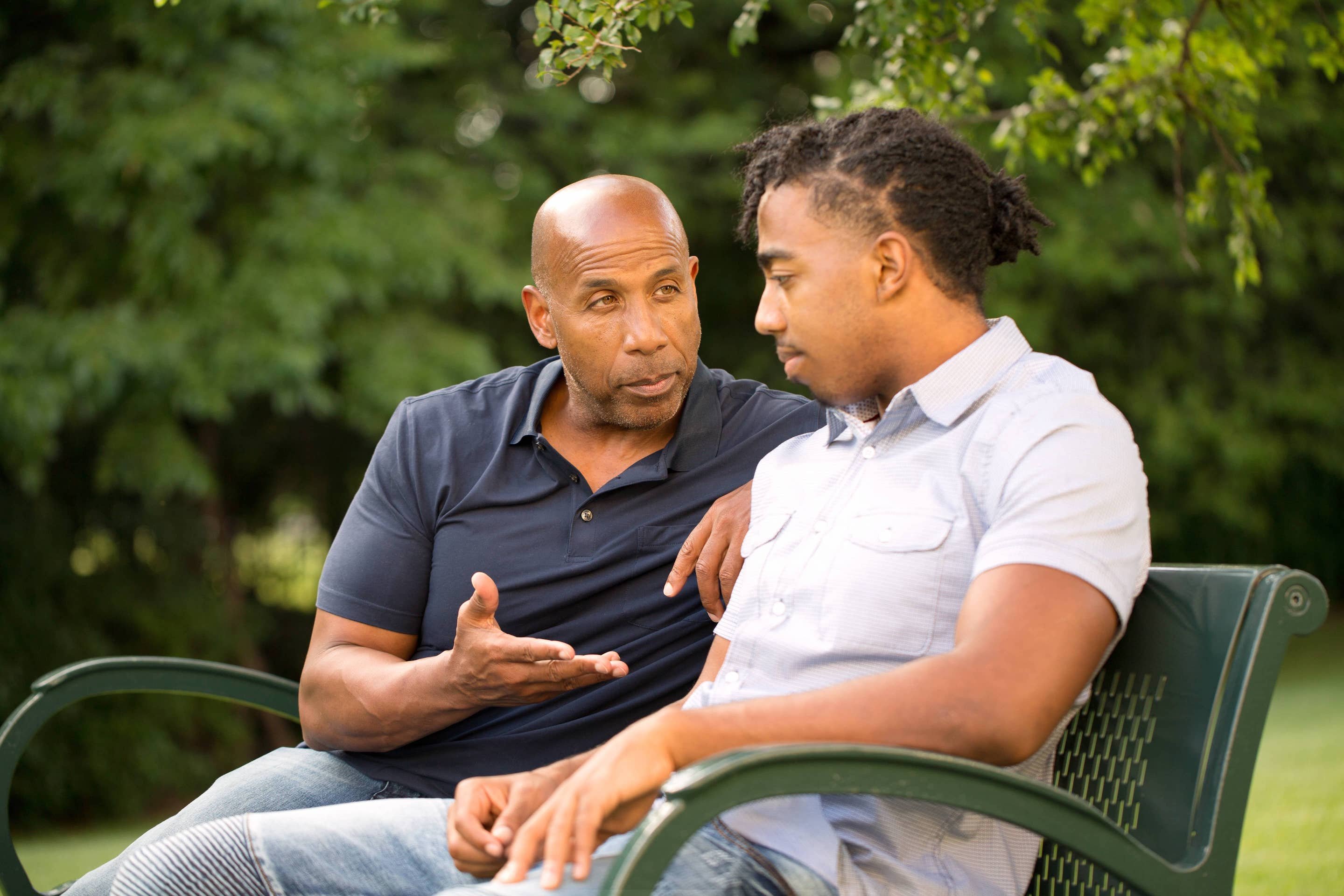 Black father giving advice to his teenage son about vaping.