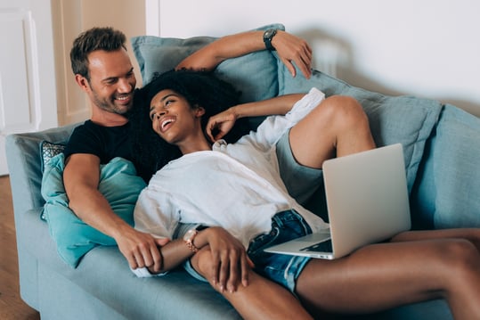 A black couple relaxing on their couch