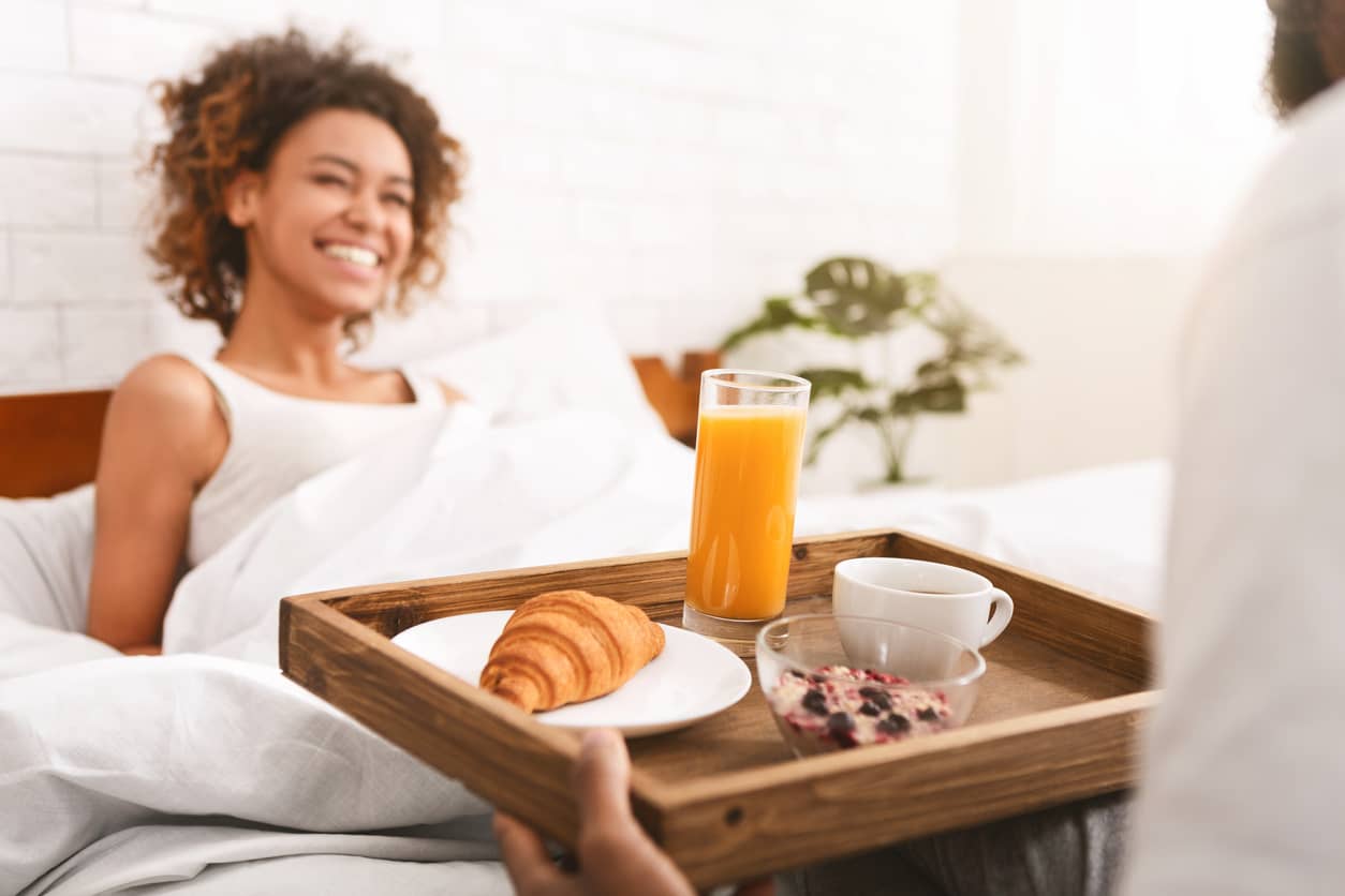 Boyfriend delivers breakfast in bed for his girlfriend who has Acts of Service as a love language.