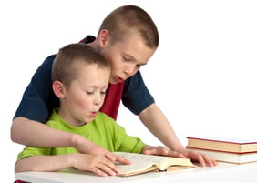 Older brother assisting his younger brother with homework.