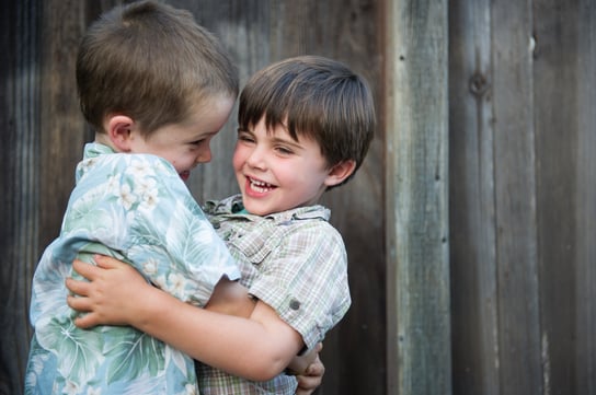 Two brothers wrestling playfully.