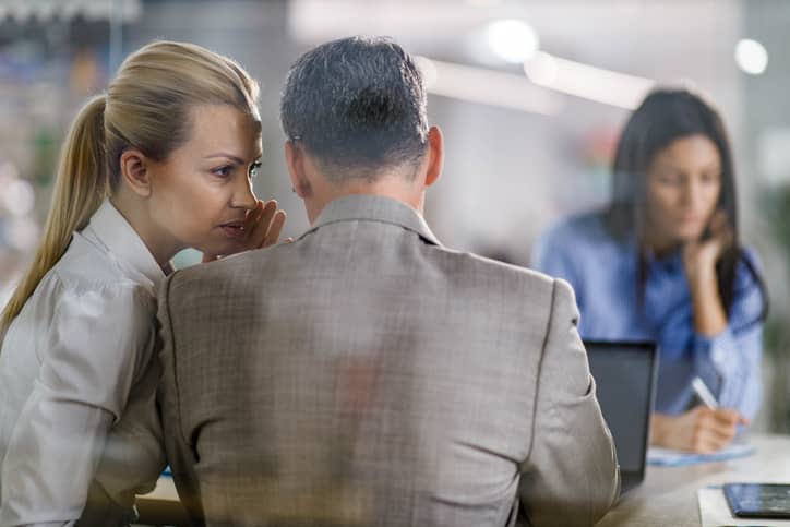 Business colleagues gossiping during a meeting in the office.