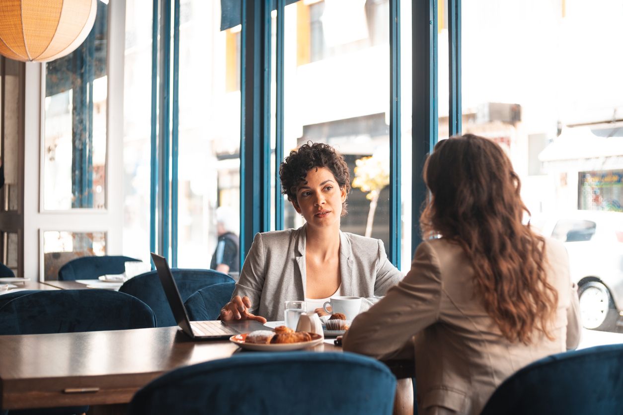 Two mompreneurs having a business meeting at a cafe.