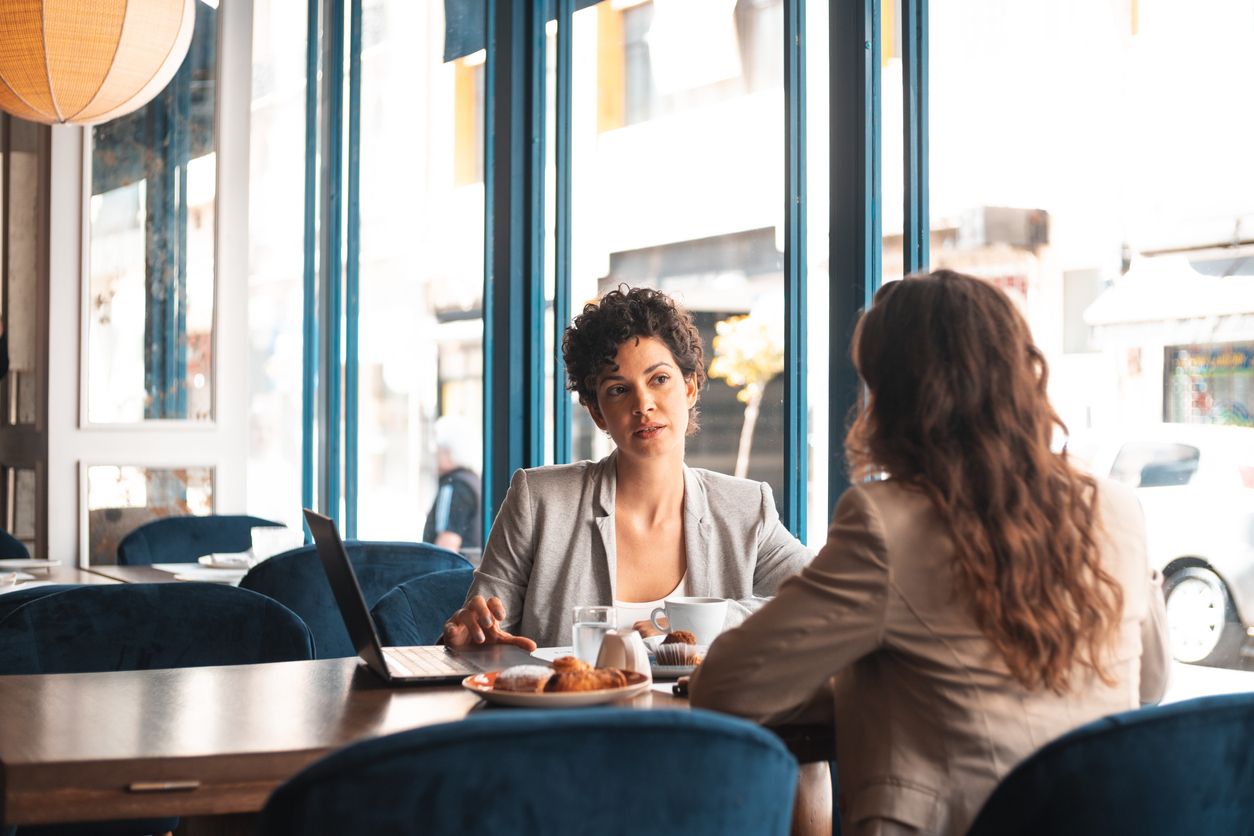 Two women talking at a cafe about self-care