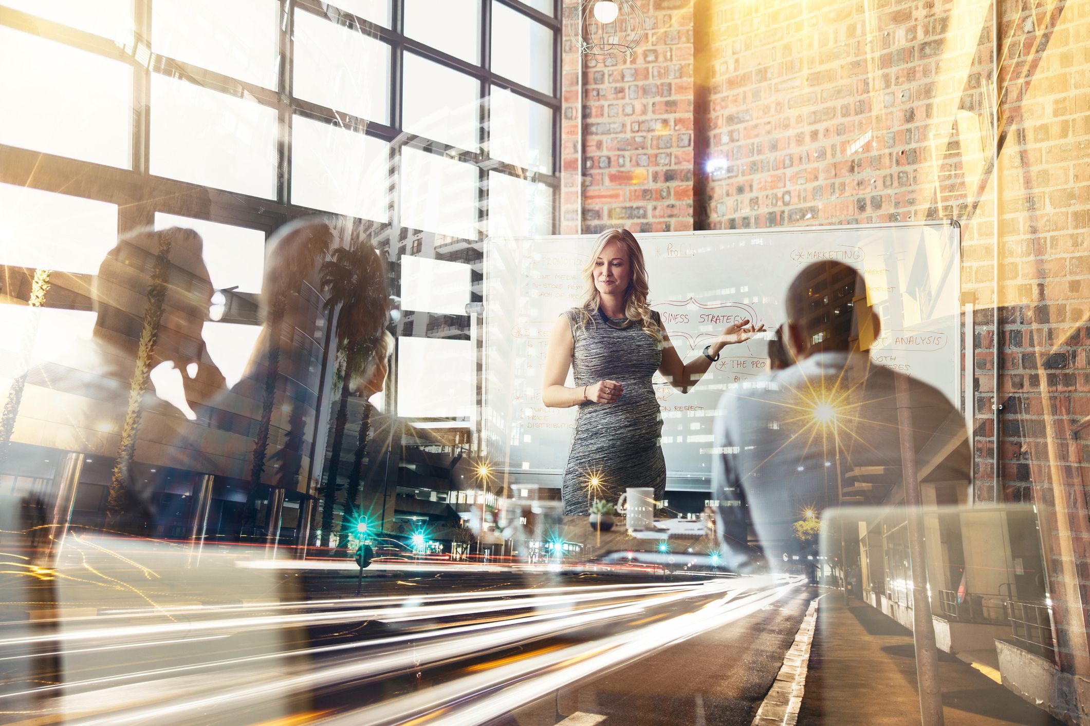 Business never stands still; pregnant woman presenting in front of group