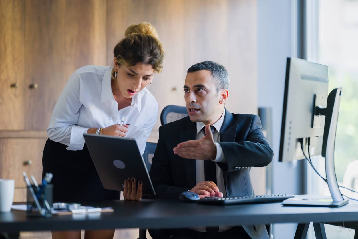 An angry businessman upset with his hand outstretched reprimanding his co-worker 