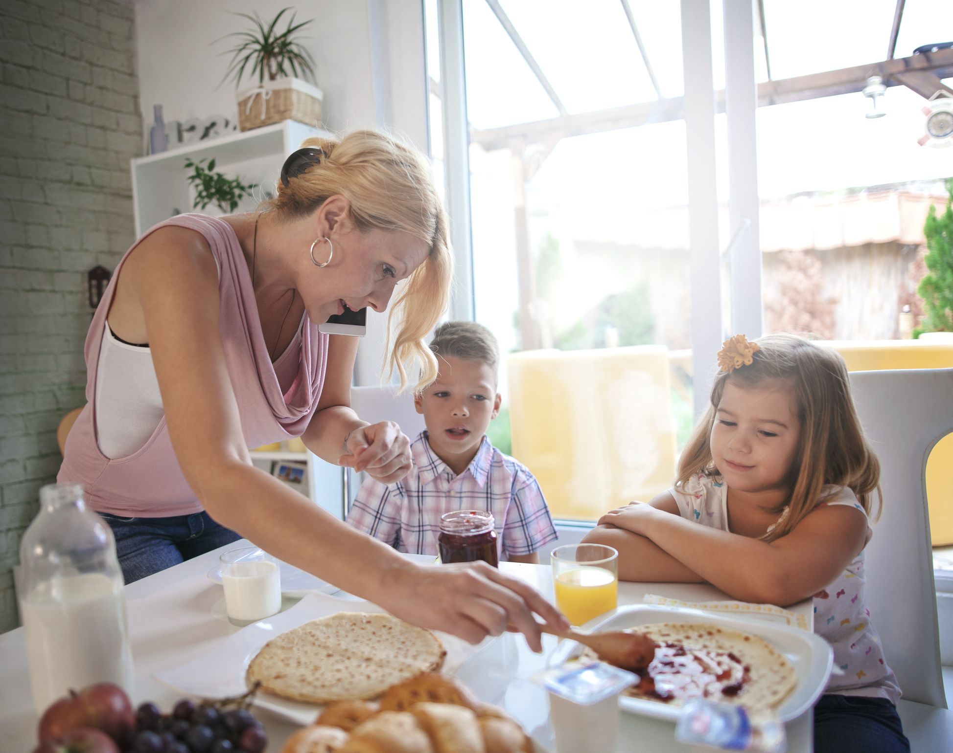 Mother serving breakfast while multitasking