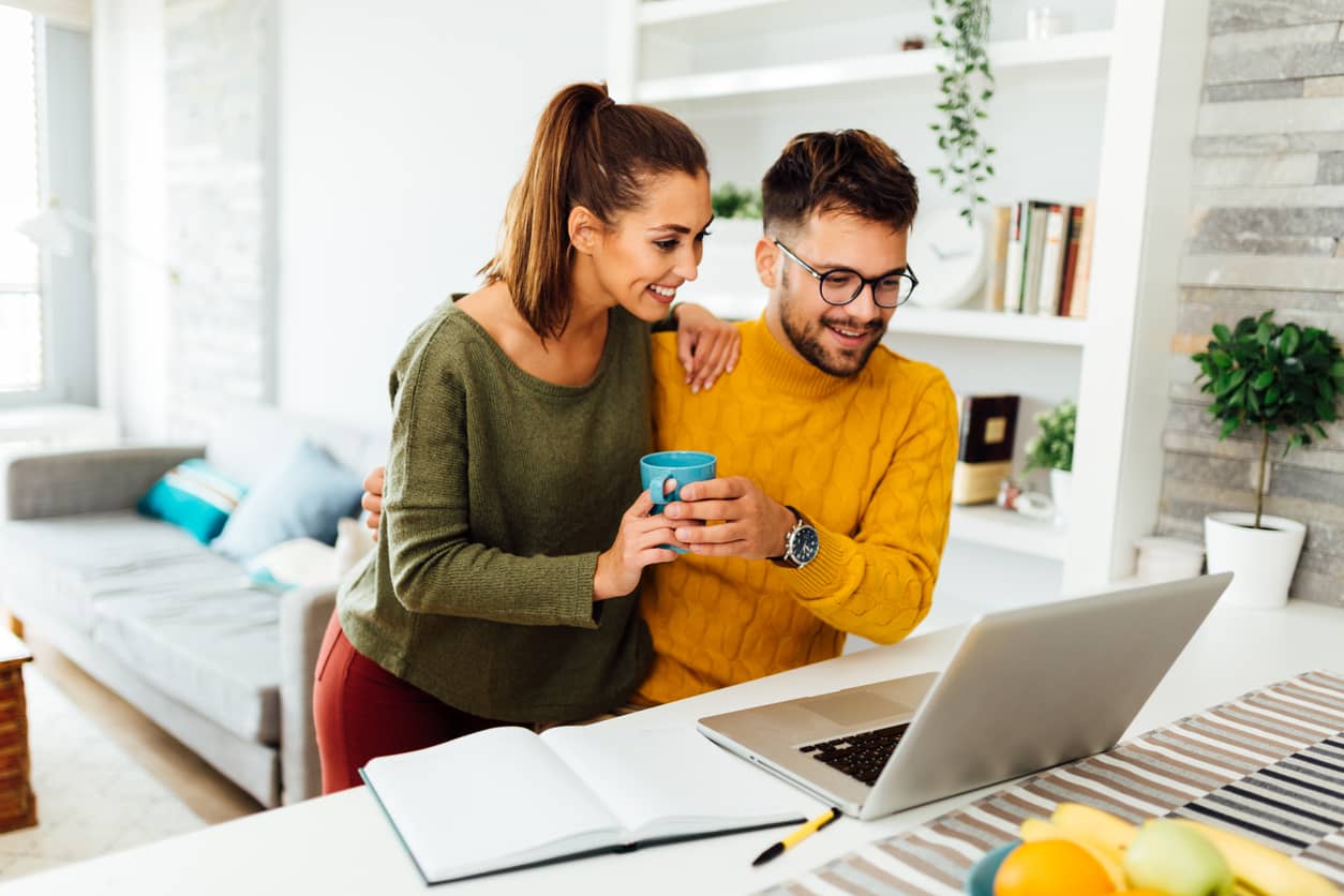 A couple working on a computer together, excited about their new business venture.