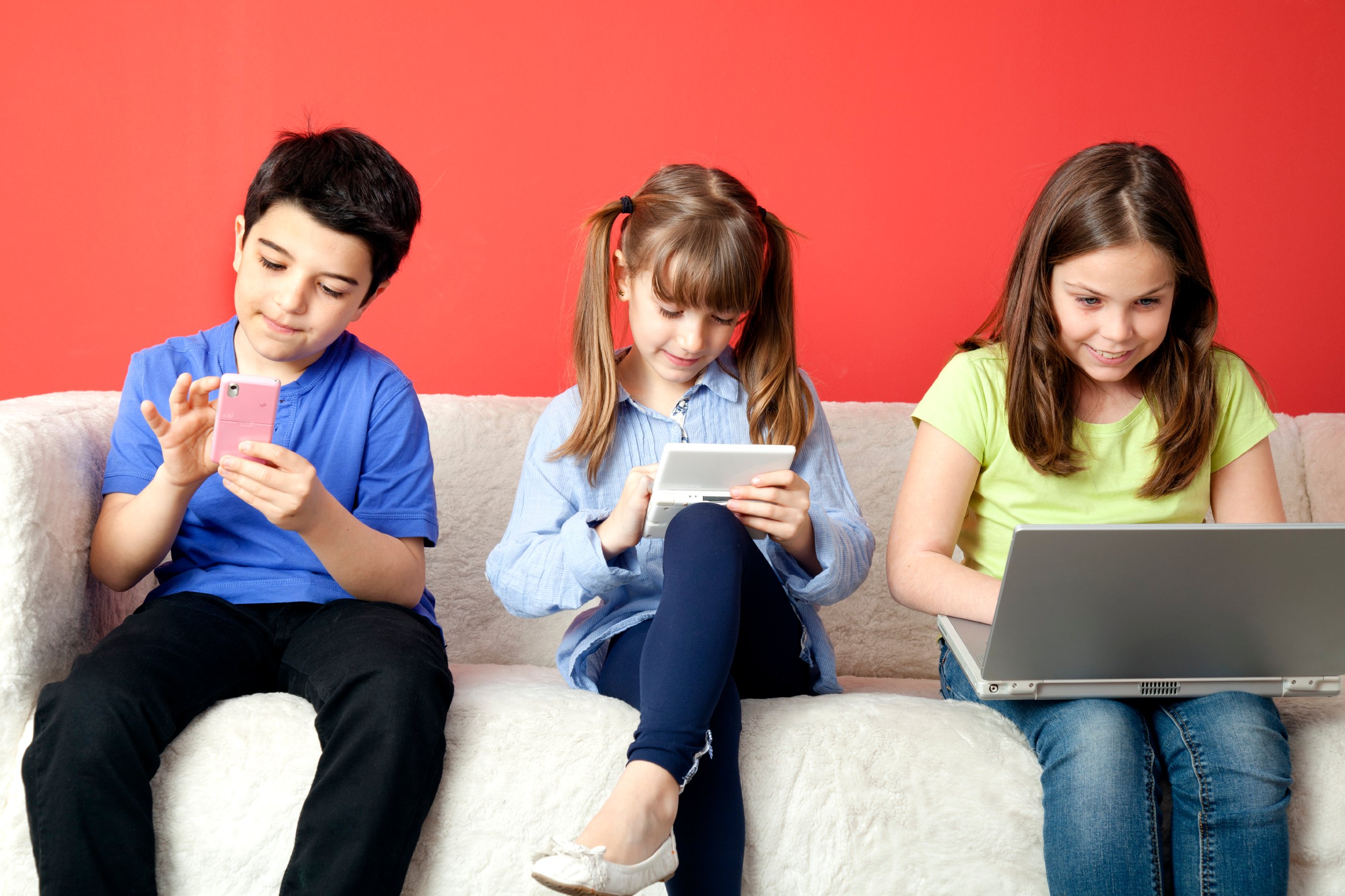 Children addicted to technology all on their phone, iPads, or computer.