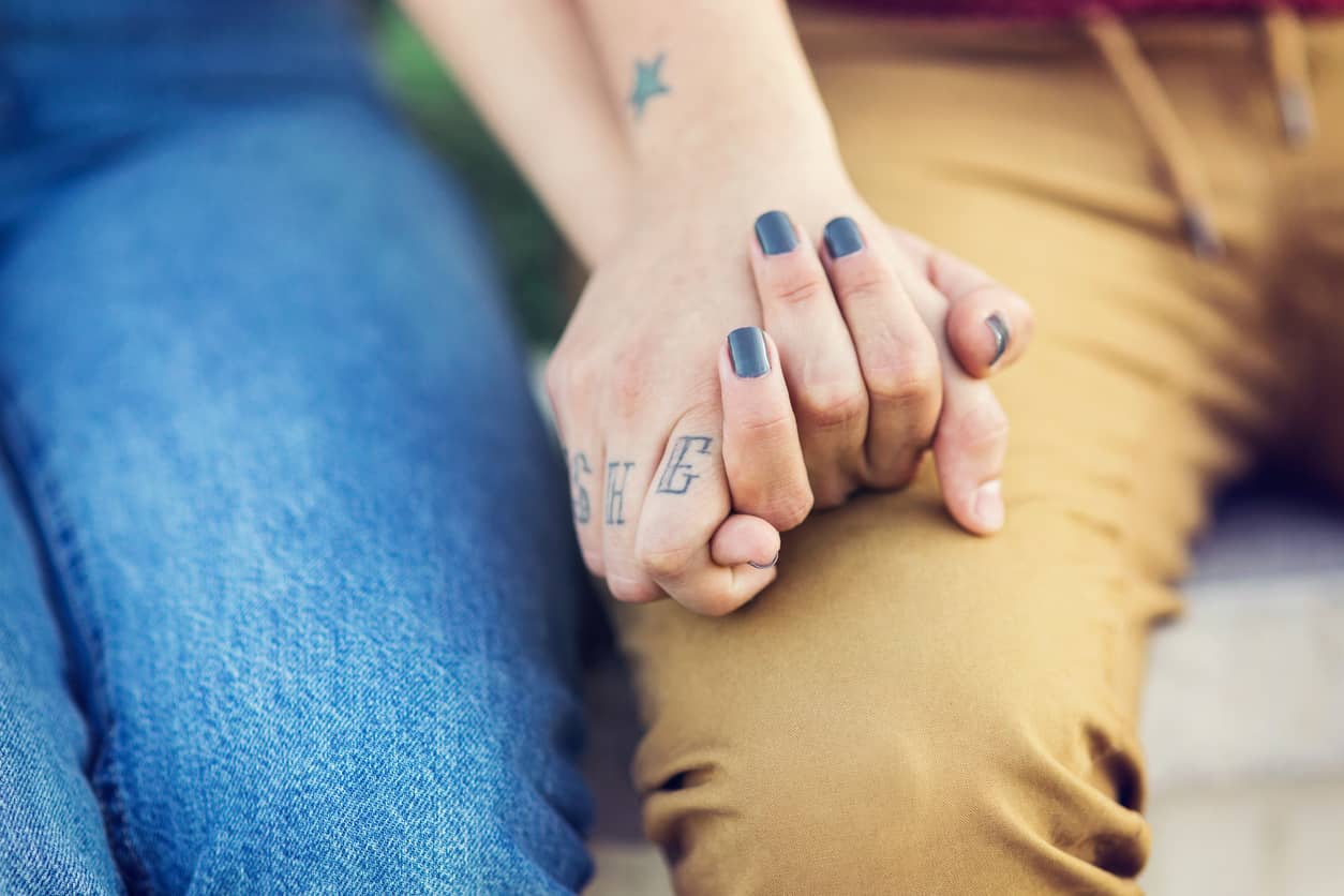 Close up of a couple holding hands.