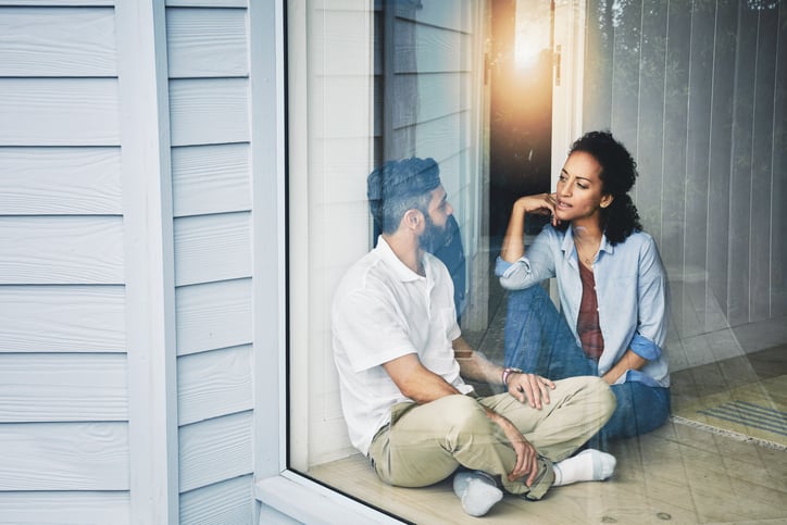 A loving couple talking on the porch, attentively listening and empathizing with one another.