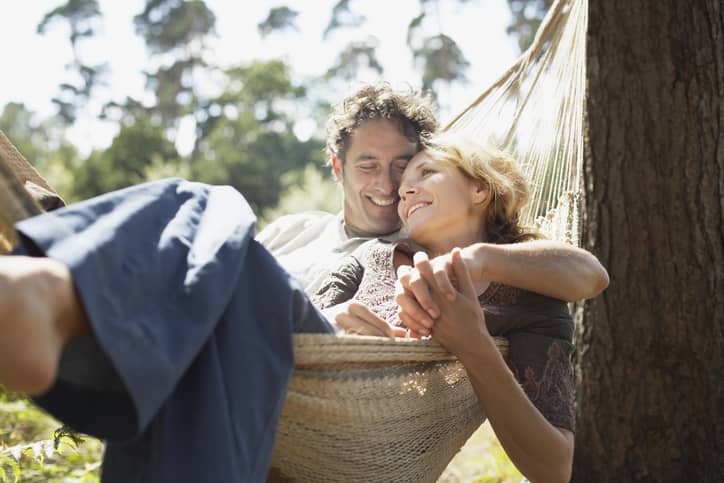 Couple lying in a hammock snuggling and talking