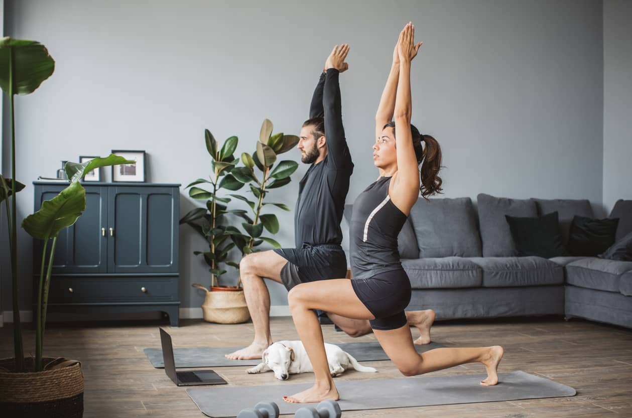 A couple practicing yoga at home