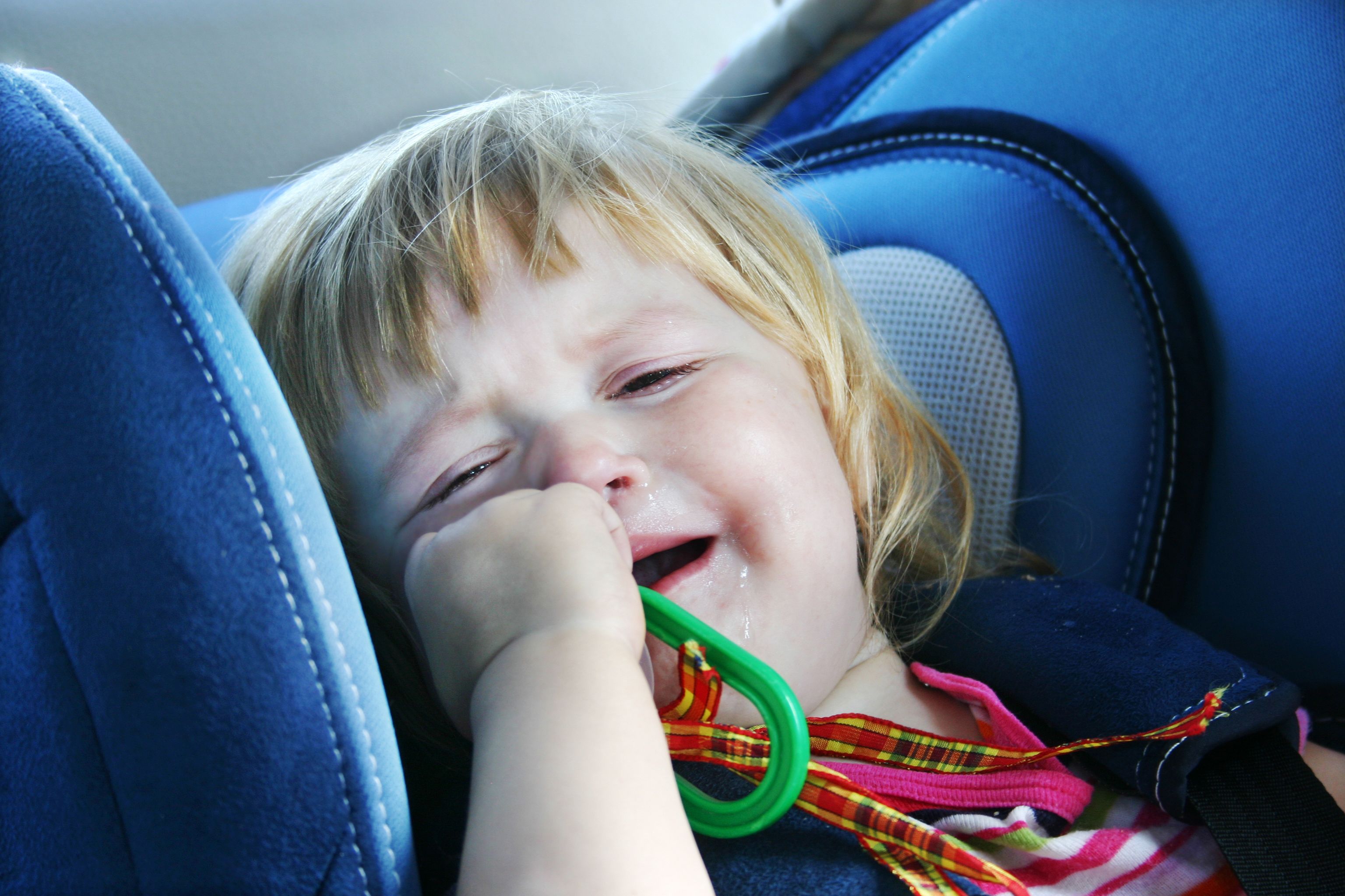 Crying toddler objecting to be in her car seat