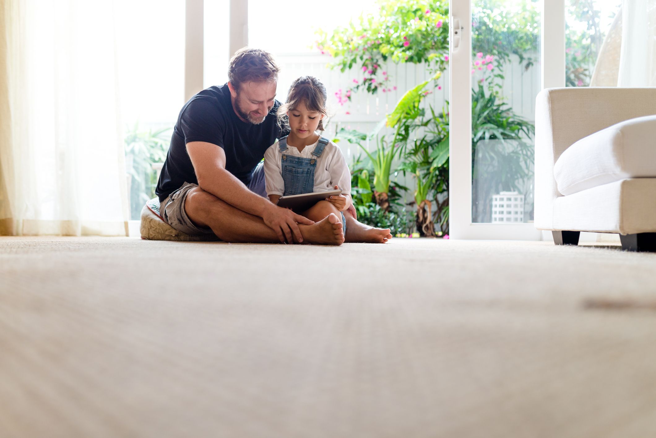 A child with mild emotional intensity calmly reads a book with her dad