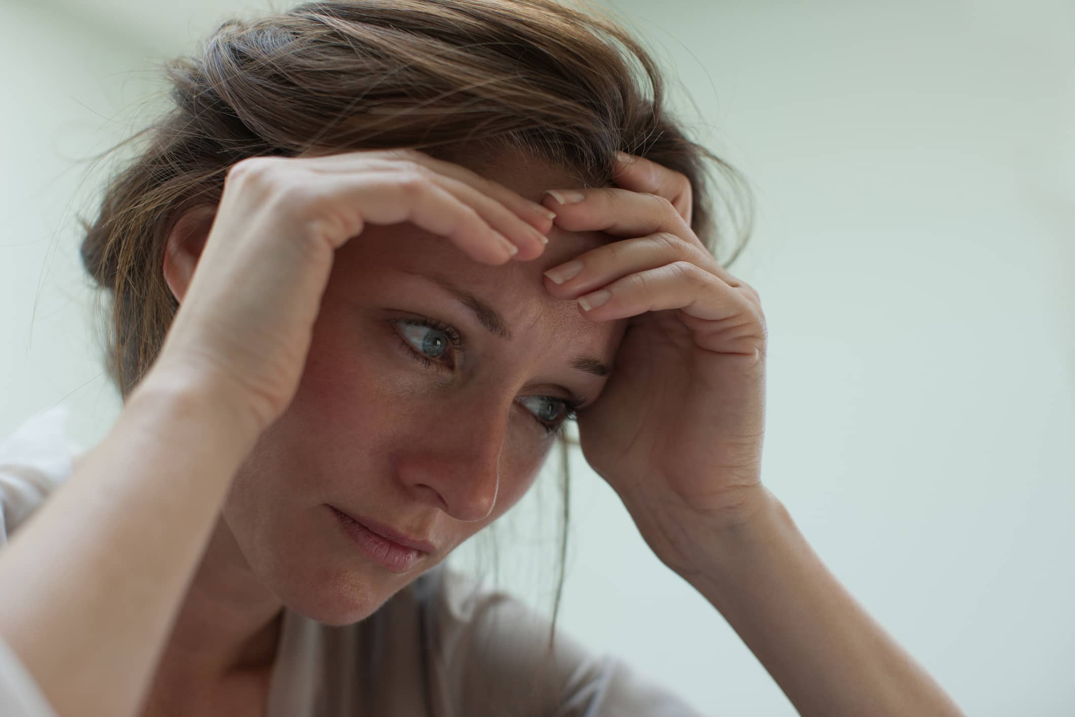 Grief stricken woman with head in her hands.