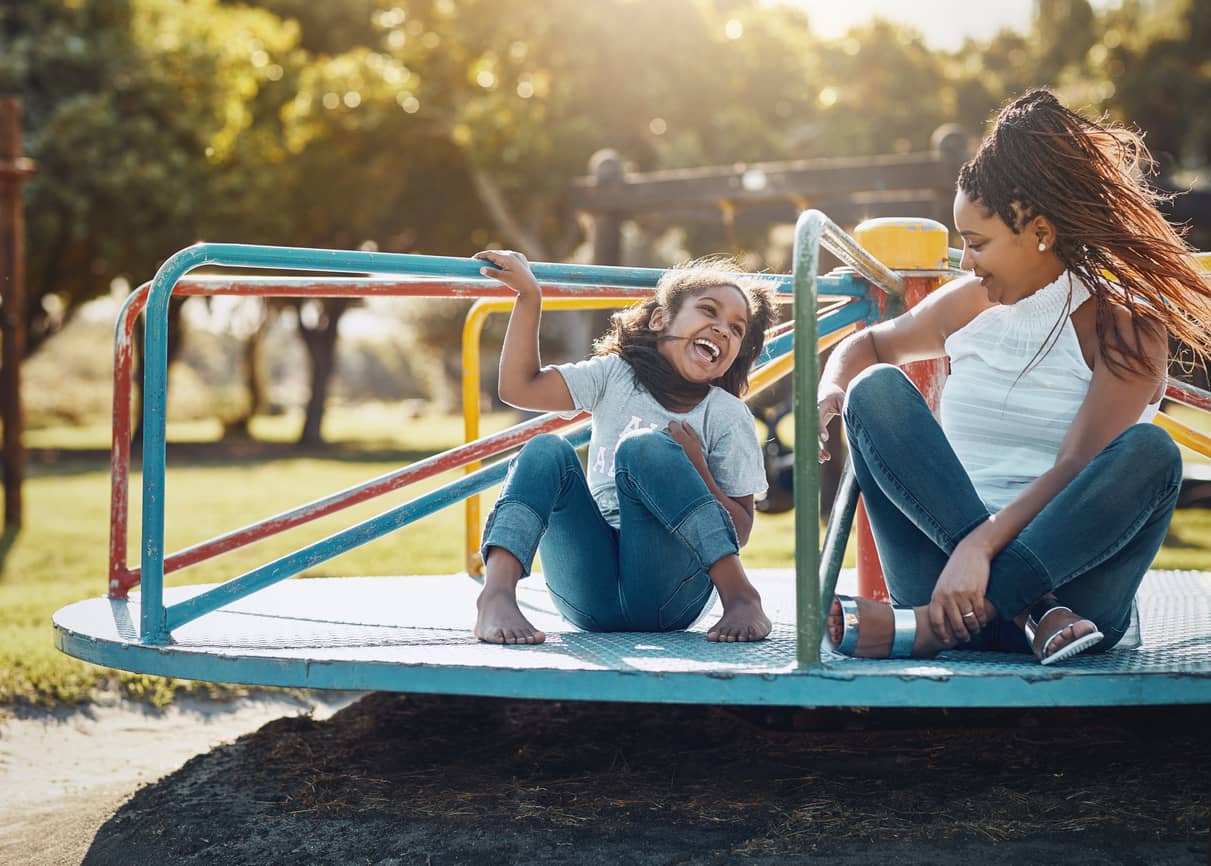 Mother and daughter on a merry-go-round having fun.