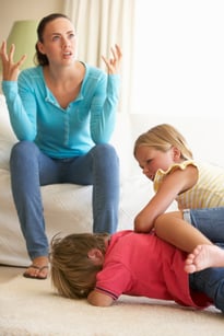 Exasperated mother with her two kids fighting.