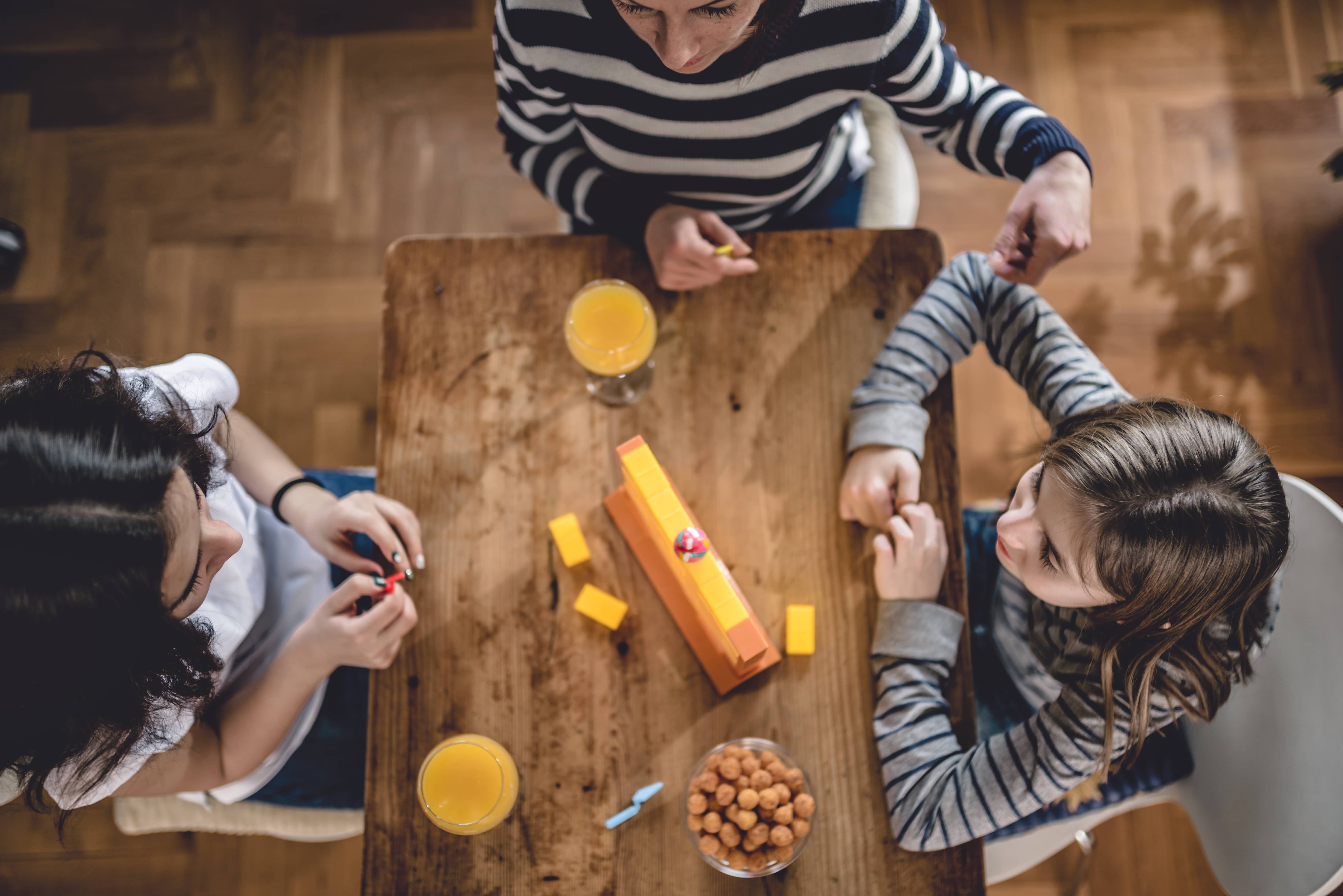 An aerial shot of a family playing a board game. 