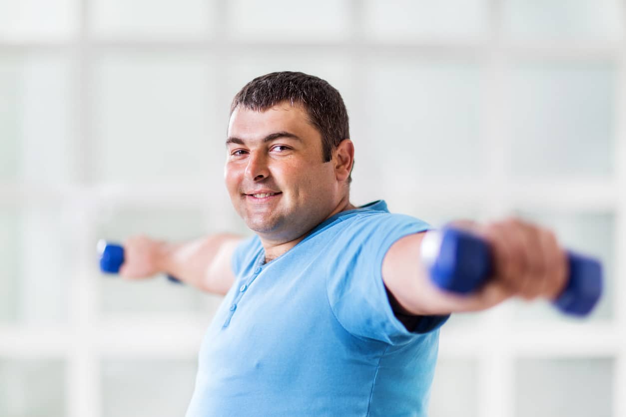 An overweight man exercising with weights.