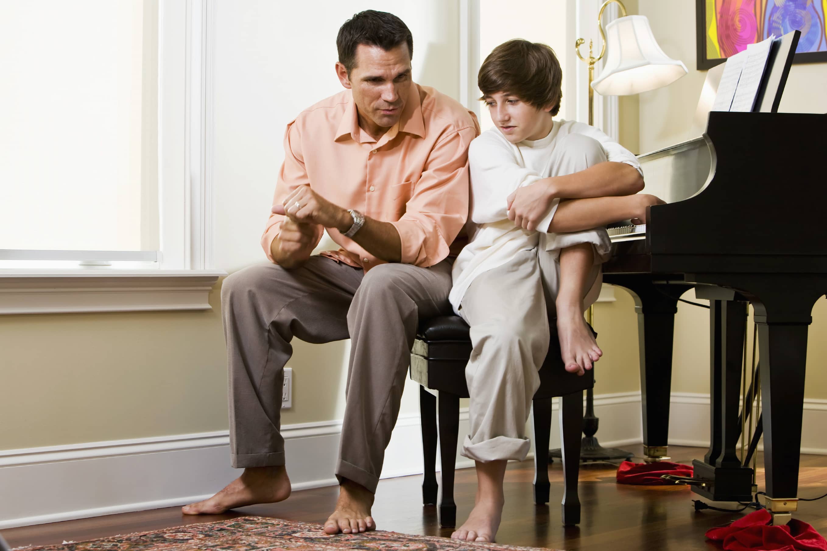 Father and son on piano bench discussing anxiety