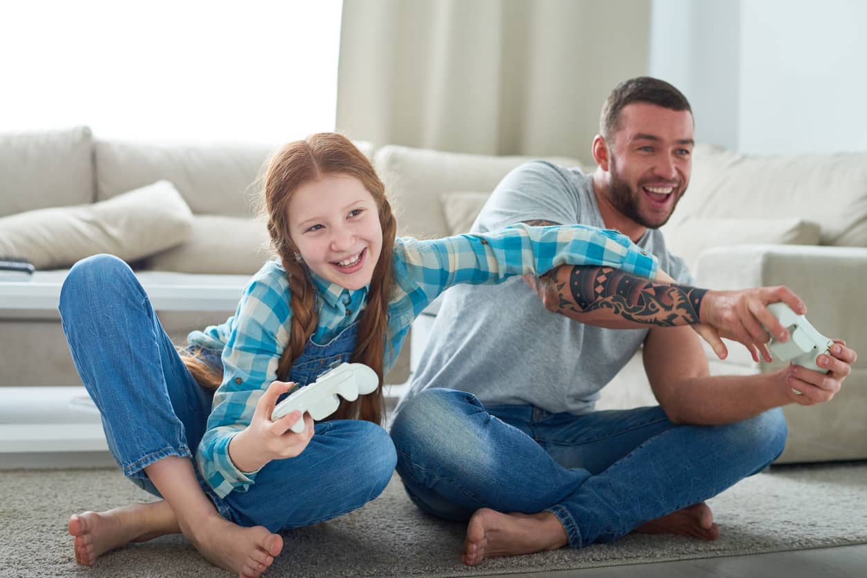 Dad playing video games with his daughter.