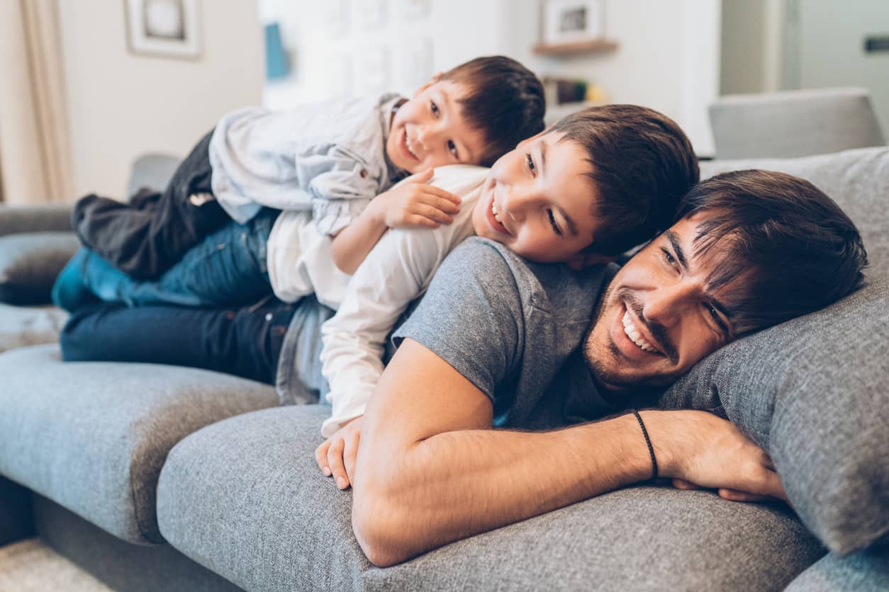 A father and his sons relaxing on the sofa.