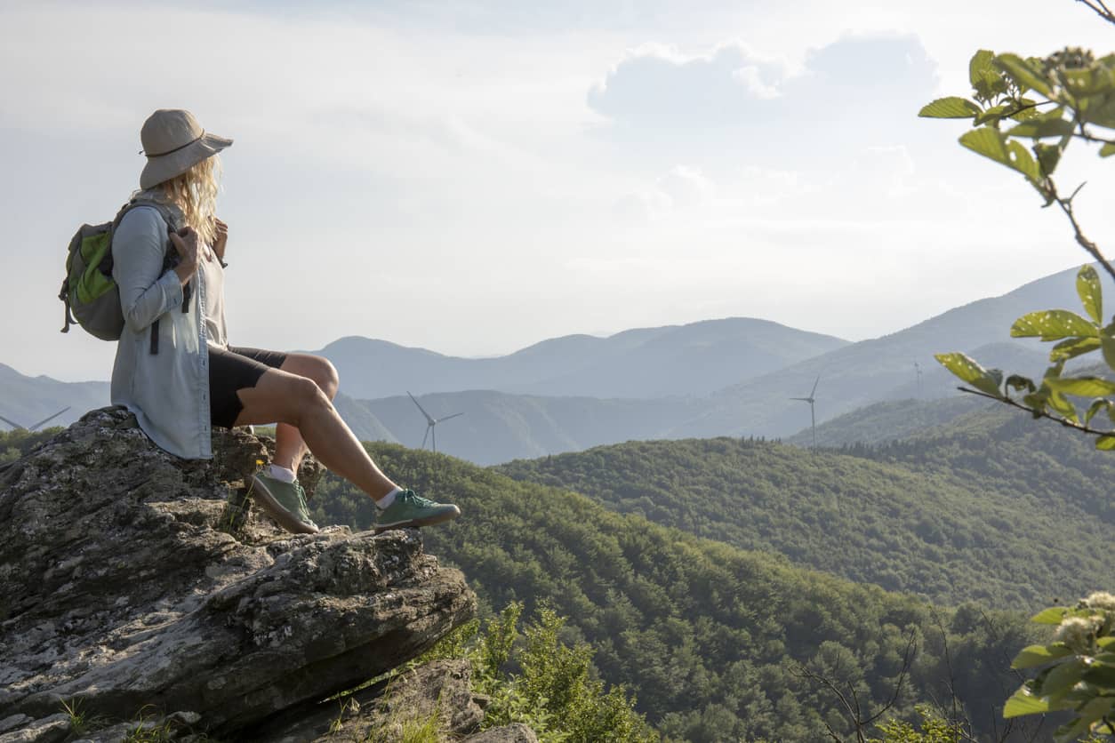 Woman sitting in self-inquiry overlooking the mountains.