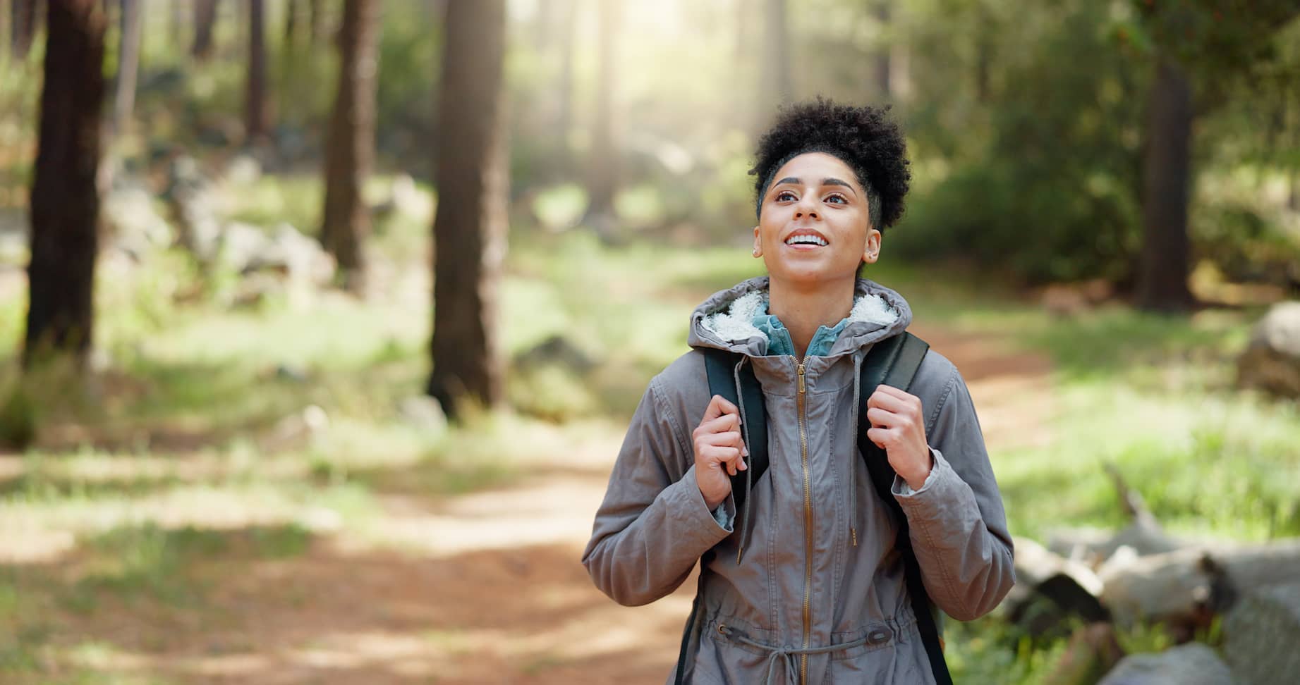 A young woman hiking in a state park to commune with nature.