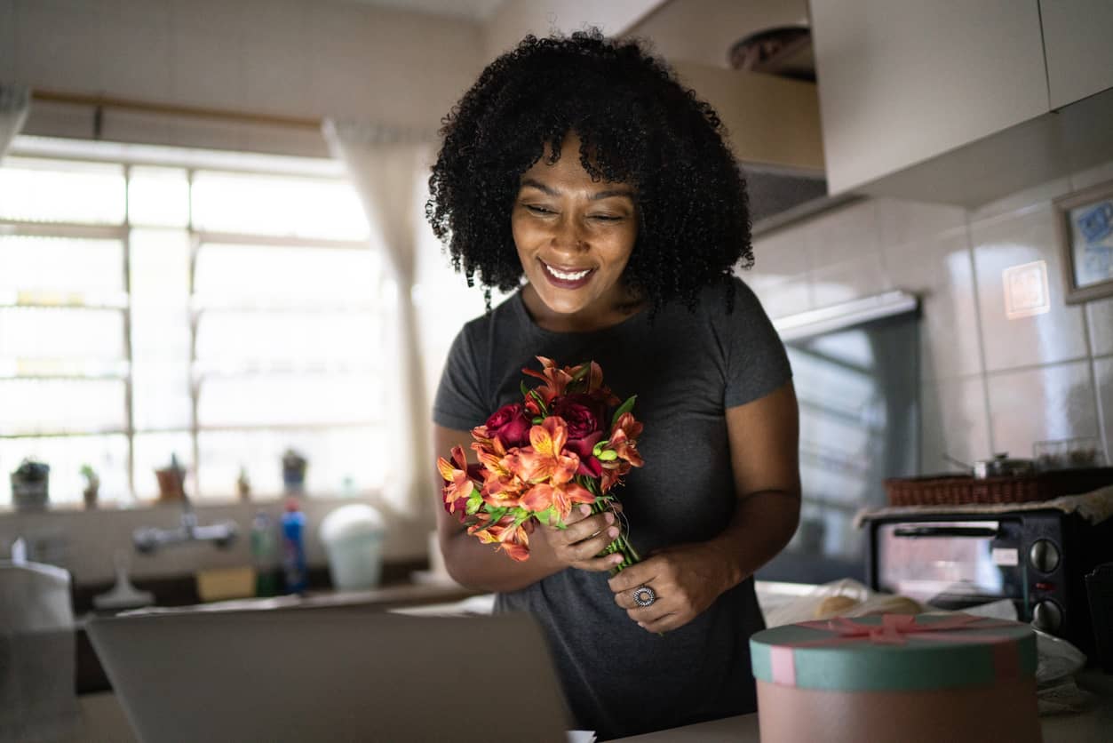 Surprised and happy girlfriend receiving flowers in a long distance relationship.